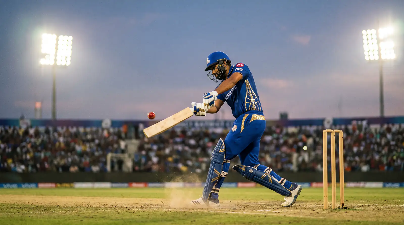 Cricket batsman in coloured kit playing an aggressive attacking shot