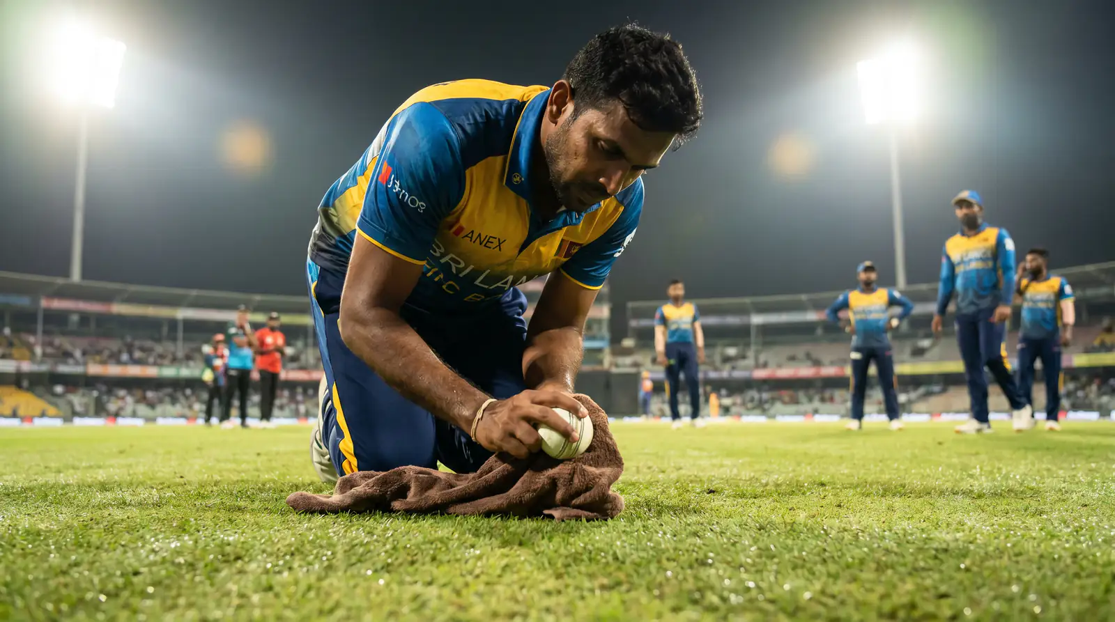 Bowler struggling to grip a dew-soaked cricket ball