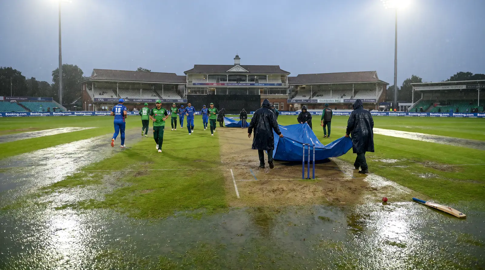 Players leaving the field as rain stops a cricket match