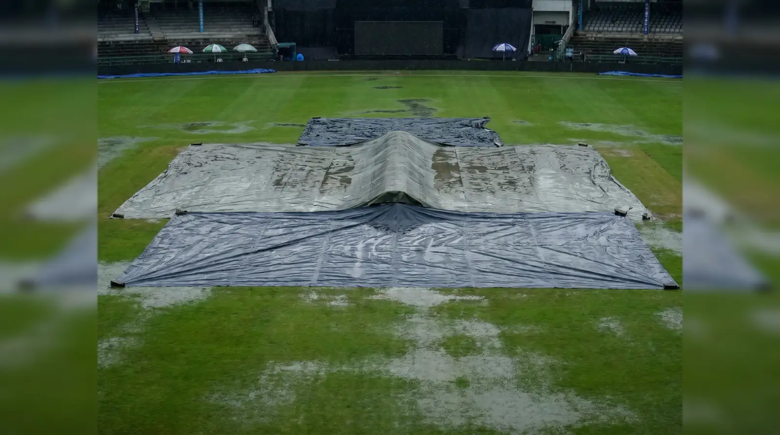 Empty cricket field under covers during a rain delay
