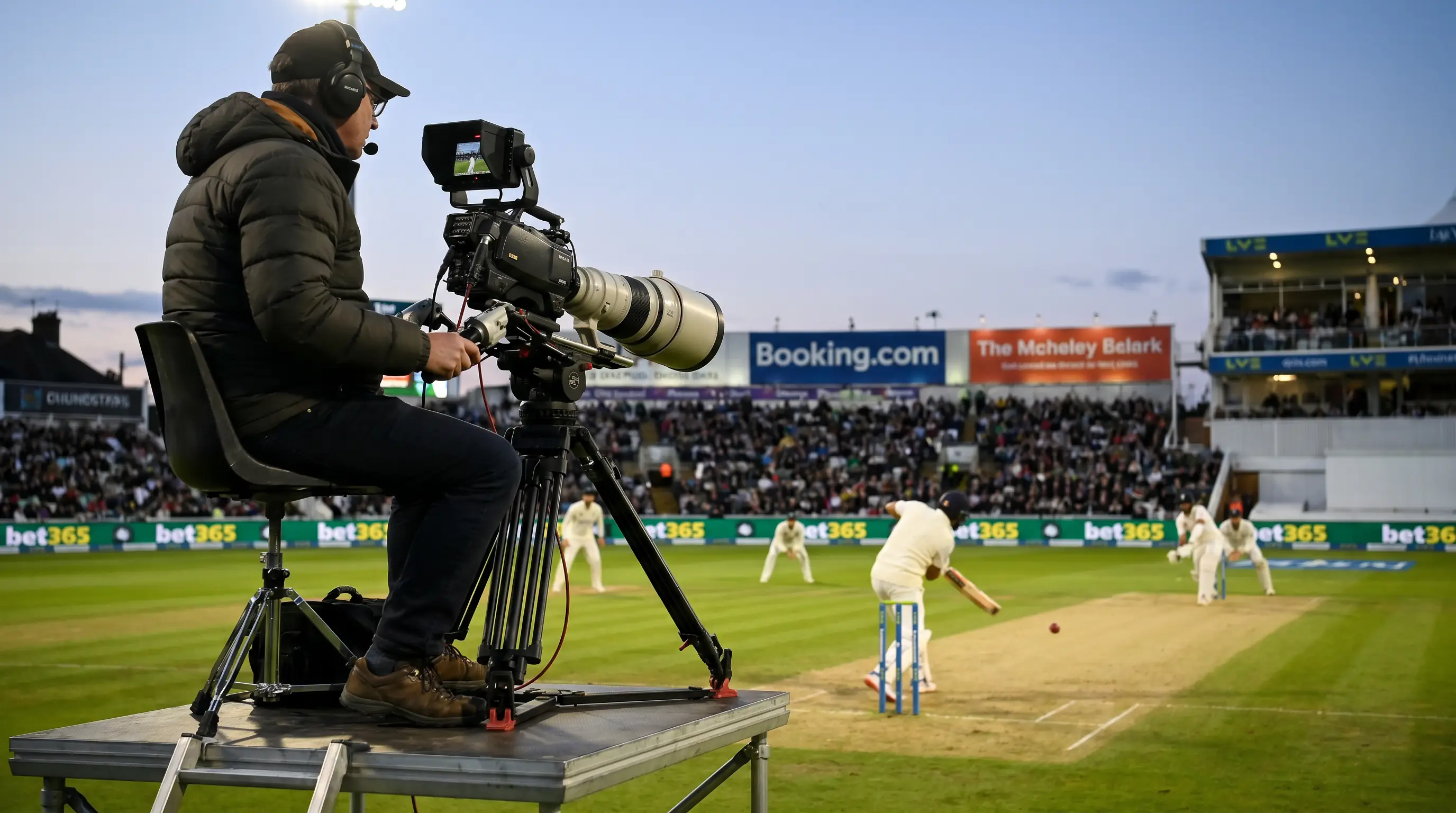 Broadcast camera operator filming a cricket match